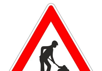 Dopravná značka upozorňujúca na práce na ceste, trojuholníková značka s červeným okrajom a čiernou siluetou muža vykonávajúceho zemné práce.