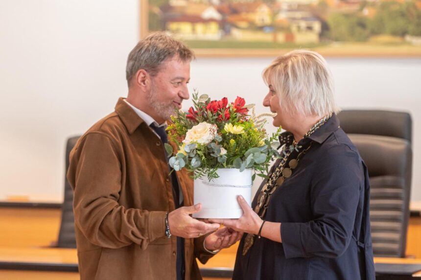 Dva ľudia si vymieňajú kyticu kvetov pri slávnostnom prijatí učiteľov v Skalici pri príležitosti Dňa učiteľov.