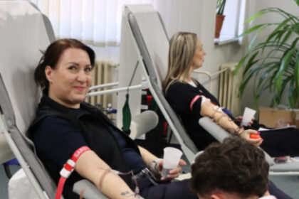 Ilustratívna fotografia z darovania krvi v Senici, zobrazuje dve ženy darujúce krv a zdravotníka so symbolom Červeného kríža pri odbere krvi.