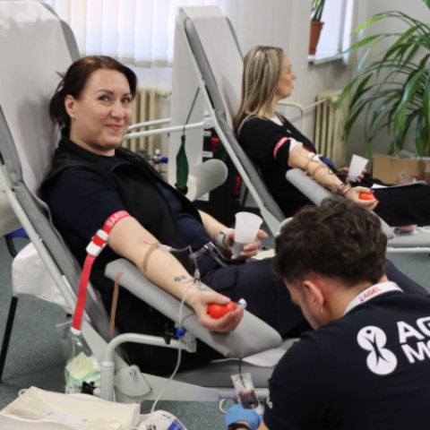 Ilustratívna fotografia z darovania krvi v Senici, zobrazuje dve ženy darujúce krv a zdravotníka so symbolom Červeného kríža pri odbere krvi.