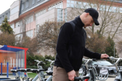 Muž stojaci pri zdieľaných bicykloch Senica BAJK pripravených na novú sezónu v meste Senica.