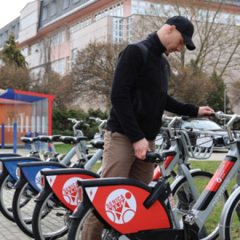 Muž stojaci pri zdieľaných bicykloch Senica BAJK pripravených na novú sezónu v meste Senica.