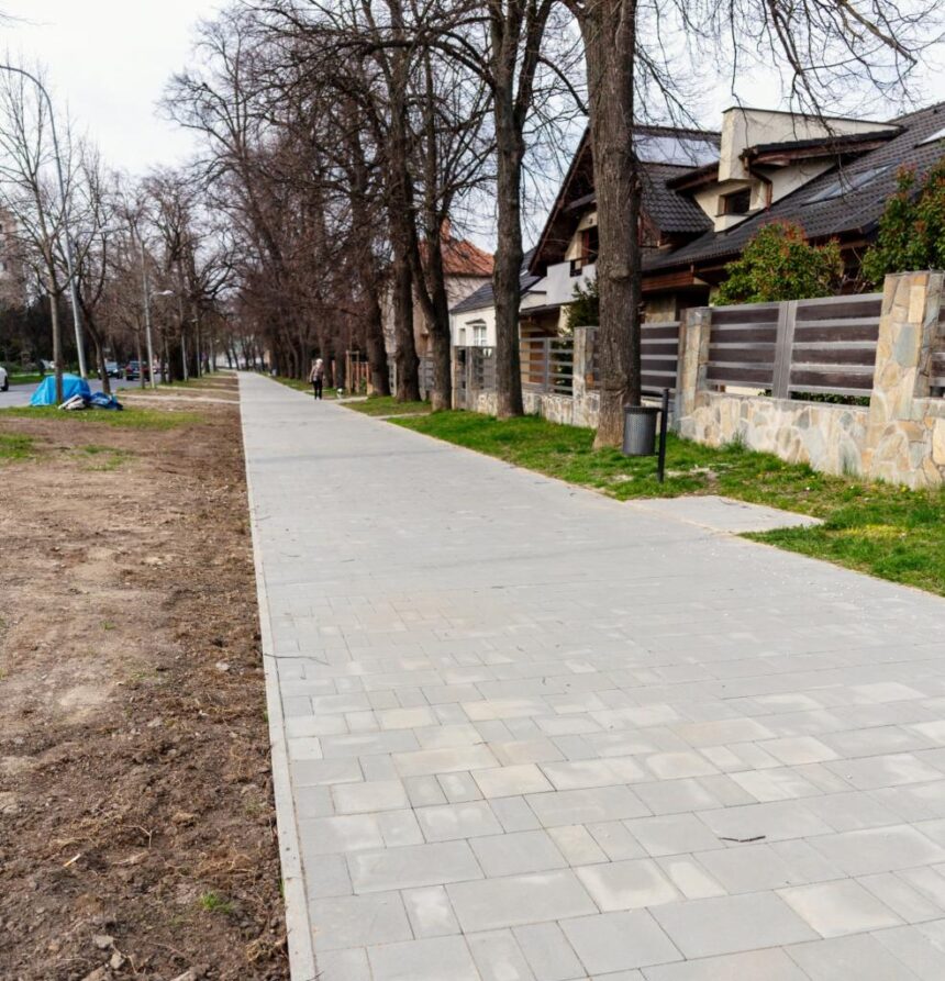 Široký nový chodník s dlažobnými kockami na Koreszkovej ulici v Skalici, obklopený stromami a domami, bez ľudí.