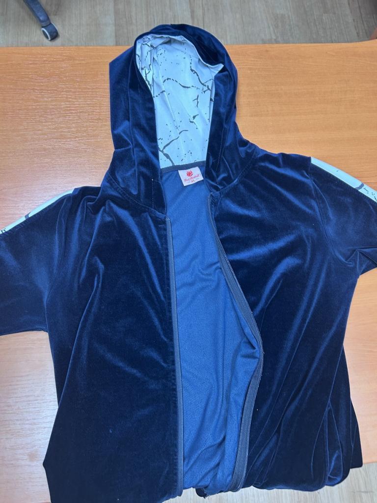 Tmavomodrá mikina s bielymi pásmi na rukávoch položená na povrchu.