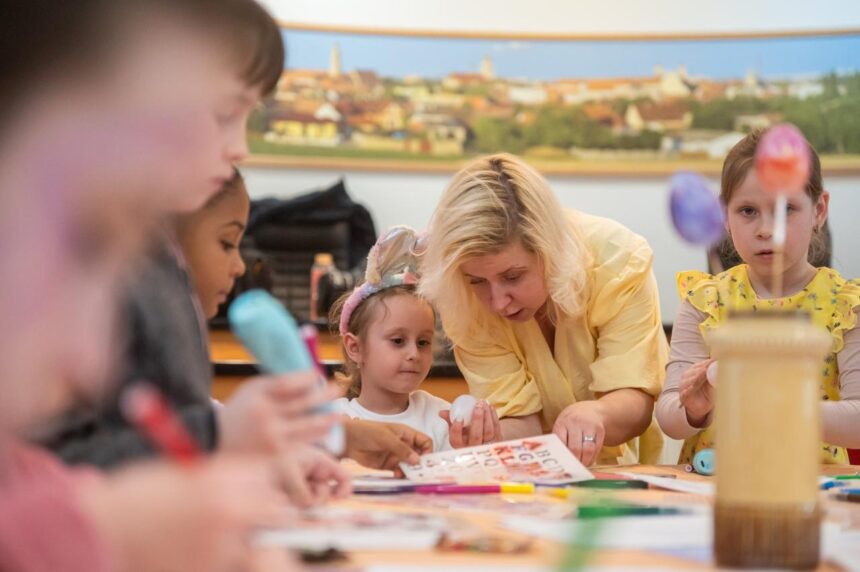 Deti a dospelá osoba pri kreatívnej veľkonočnej aktivite na Skalickej radnici, na stole sú umelecké potreby.