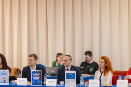 Prednášajúci a účastníci súťaže Mladý Európan 2026 v Kultúrnom dome v Senici, vidieť vlajky krajín a atmosféru podujatia.