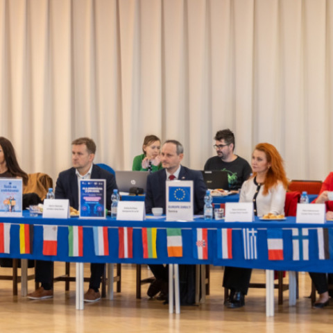 Prednášajúci a účastníci súťaže Mladý Európan 2026 v Kultúrnom dome v Senici, vidieť vlajky krajín a atmosféru podujatia.