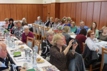 Sála plná ľudí sediacich pri stoloch na sneme okresnej organizácie JDS v Senici.