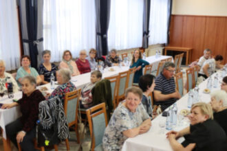 Skupina ľudí sediacich pri dlhom stole počas výročnej schôdze Únie nevidiacich a slabozrakých v Senici.