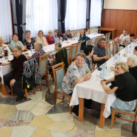 Skupina ľudí sediacich pri dlhom stole počas výročnej schôdze Únie nevidiacich a slabozrakých v Senici.