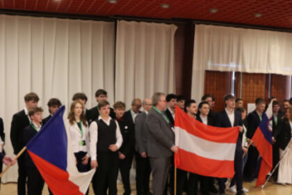 Skupina mladých inovátorov na konferencii Enersol v Senici, držia vlajky Českej republiky a Rakúska.
