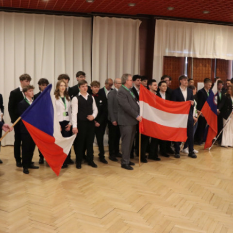 Skupina mladých inovátorov na konferencii Enersol v Senici, držia vlajky Českej republiky a Rakúska.