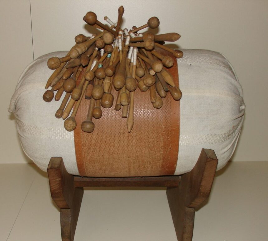 Vankúš na paličkovanie s množstvom paličiek, ktoré sú rozmiestnené na vrchu, ilustrujúci tradičné remeslo v Záhorskom múzeu Skalica.