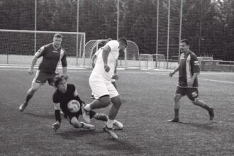 Fotografia z futbalového zápasu na trávnatom ihrisku, štyria hráči v rôznych dresoch počas malého futbalu v Skalici.