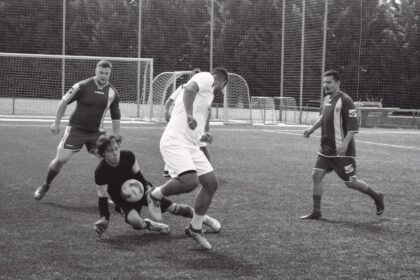Fotografia z futbalového zápasu na trávnatom ihrisku, štyria hráči v rôznych dresoch počas malého futbalu v Skalici.