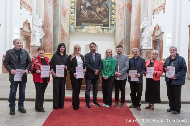 Skupina ľudí oblečených formálne drží diplomy na vernisáži výstavy Skalická paleta 2026, v pozadí sú viditeľné umelecké diela.