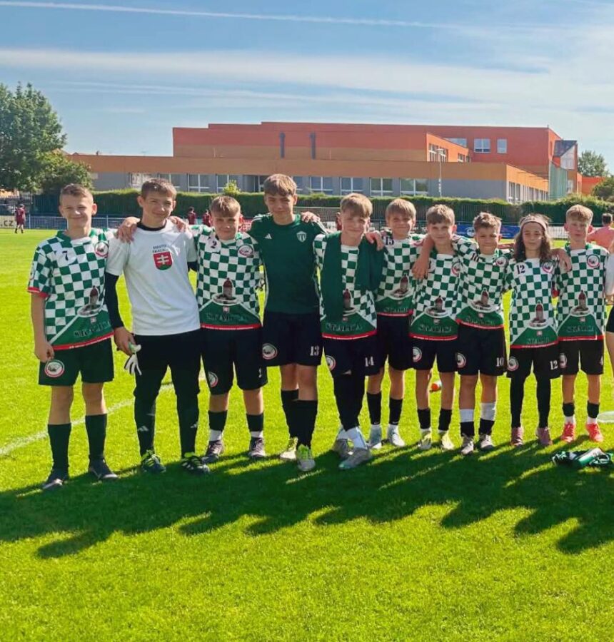 Skupina mladých futbalistov zo Skalice v čierno-bielych dresoch na futbalovom ihrisku počas turnaja.