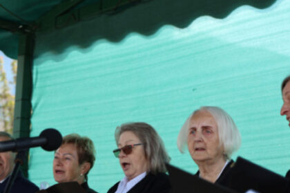 Skupina spevákov zo speváckeho zboru Seniorka spievajúcich na pódiu počas kultúrneho programu na Námestí oslobodenia v Senici.