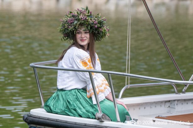Žena v tradičnom kroji s vencom na hlave sedí na lodi na Baťovom kanáli počas otvorenia plavebnej sezóny v Skalice.