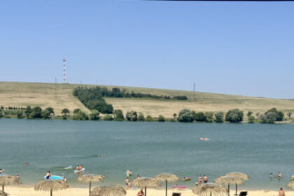Pláž Kunovskej priehrady v Senici s novými ležadlami a slnečníkmi, ľudia sa kúpajú vo vode.