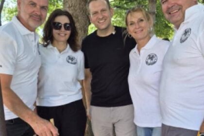 Skupina piatich ľudí pri veľkom hrnci počas varenia guláša na Gulášovej súťaži v Senici v areáli hostinca U troch dedkú.