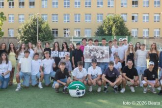Skupinová fotografia žiakov na trávniku pred základnou školou v Skalici počas rozlúčky so školským rokom, niektorí majú tabuľky s označením tried 9.A a 9.B.
