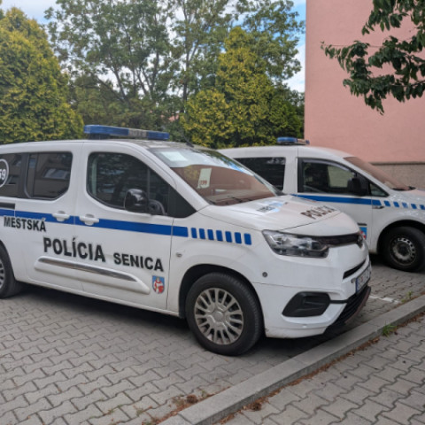 Dve vozidlá Mestskej polície Senica zaparkované vedľa seba na mestskom parkovisku.