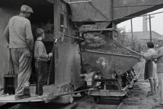 Pracovníci v skalickej tehelni pri nakladaní materiálu do vozíka na koľajniciach.