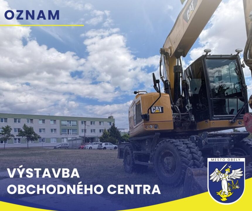 Stavebný stroj pri budove počas prípravných prác na výstavbe.