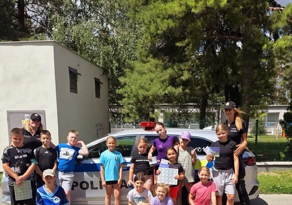 Deti s policajtkami pri policajnom aute