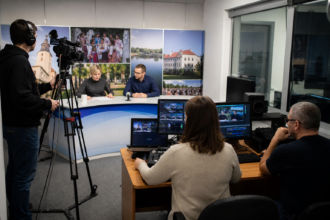 Lokálne televízne štúdio s kamerou a monitorom pri príprave spravodajstva.