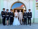 Svadobná skupinová fotografia pred budovou mestského úradu.