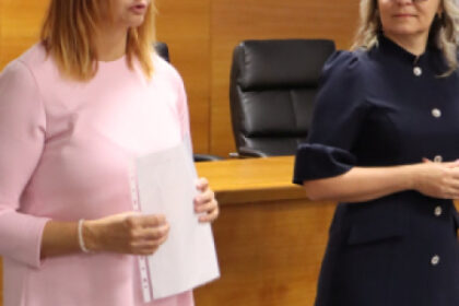 Ľudia sediaci na odbornej prednáške v interiéri.