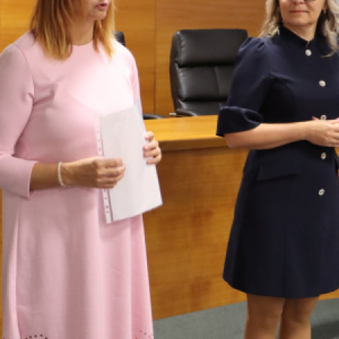 Ľudia sediaci na odbornej prednáške v interiéri.