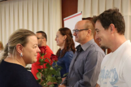 Ocenení darcovia krvi si na slávnostnom podujatí v Senici podávajú ruky pri preberaní ocenenia.