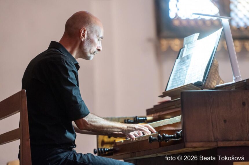 Organista hrá na organe v interiéri kostola.