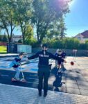Deti na dopravnom ihrisku s policajtom počas výučby pravidiel cestnej premávky.
