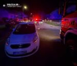 Nočná dopravná nehoda na ceste s policajnými a hasičskými vozidlami so zapnutými majákmi.