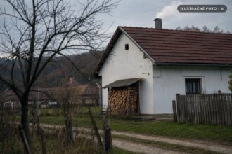 Rodinný dom so komínom a pripraveným drevom počas vykurovacej sezóny