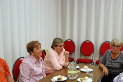 Seniori sediaci pri stole na spoločnom posedení v interiéri