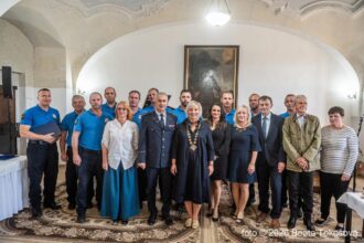 Skupinová fotografia účastníkov slávnostného podujatia v interiéri.